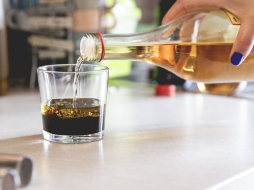 In un bicchiere vengono versati olio e aceto per la salsina