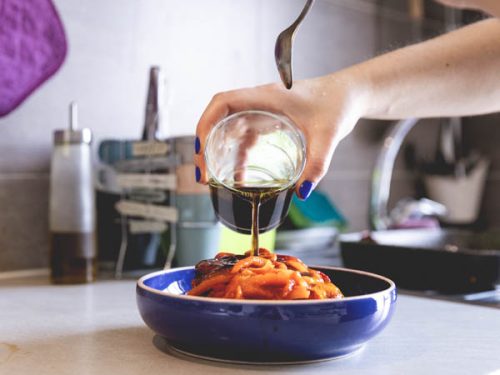 La salsina di olio, aceto, sale e pepe viene versati sui peperoni